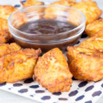 Bolinhos de batata recheados com queijo muçarela, fritos até ficarem dourados, servidos com um molho especial.