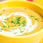 Foto de uma sopa de batata cremosa em uma tigela amarela.