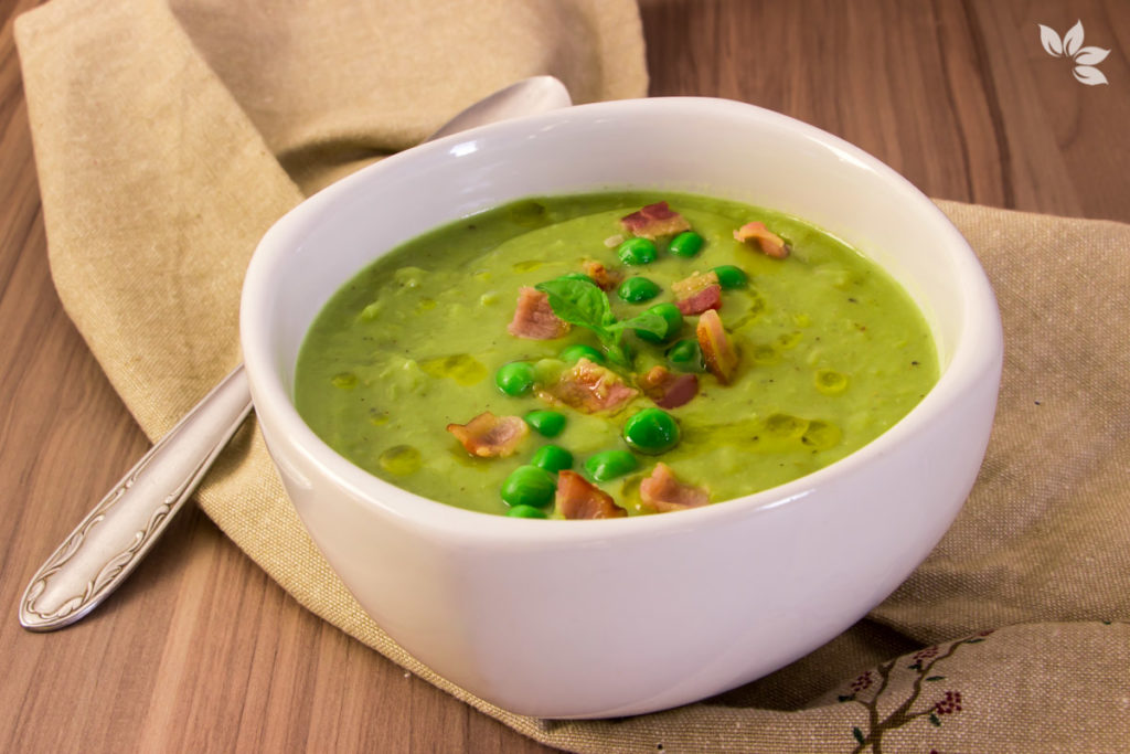 Sopa verde de ervilha em tigela branca com toque rústico