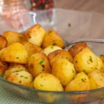 Batata sauté dourada na frigideira, salpicada com salsinha fresca.