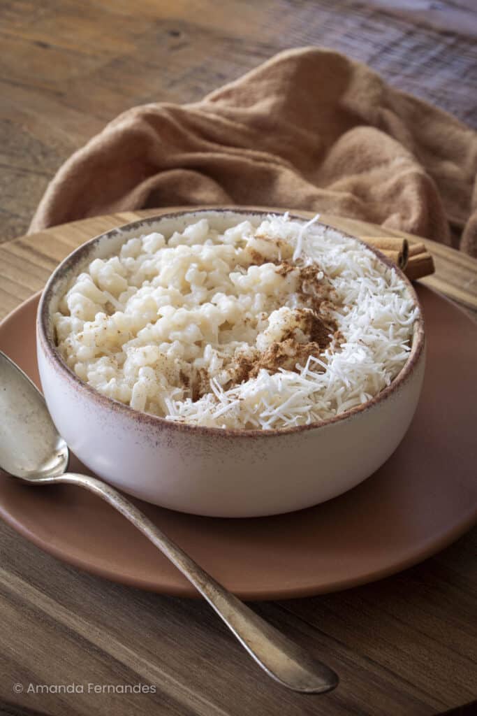 Close no arroz doce com coco e canela, mostrando a cremosidade da receita afetiva.