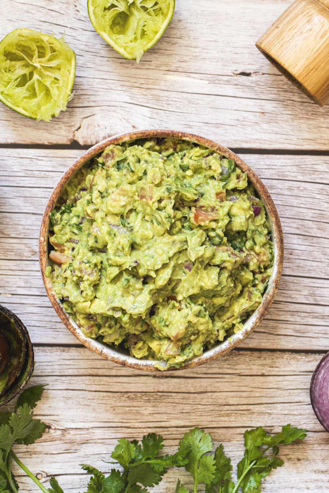 Guacamole caseiro cremoso com pedaços de abacate, tomate e coentro