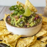 Guacamole servido com nachos crocantes e limão